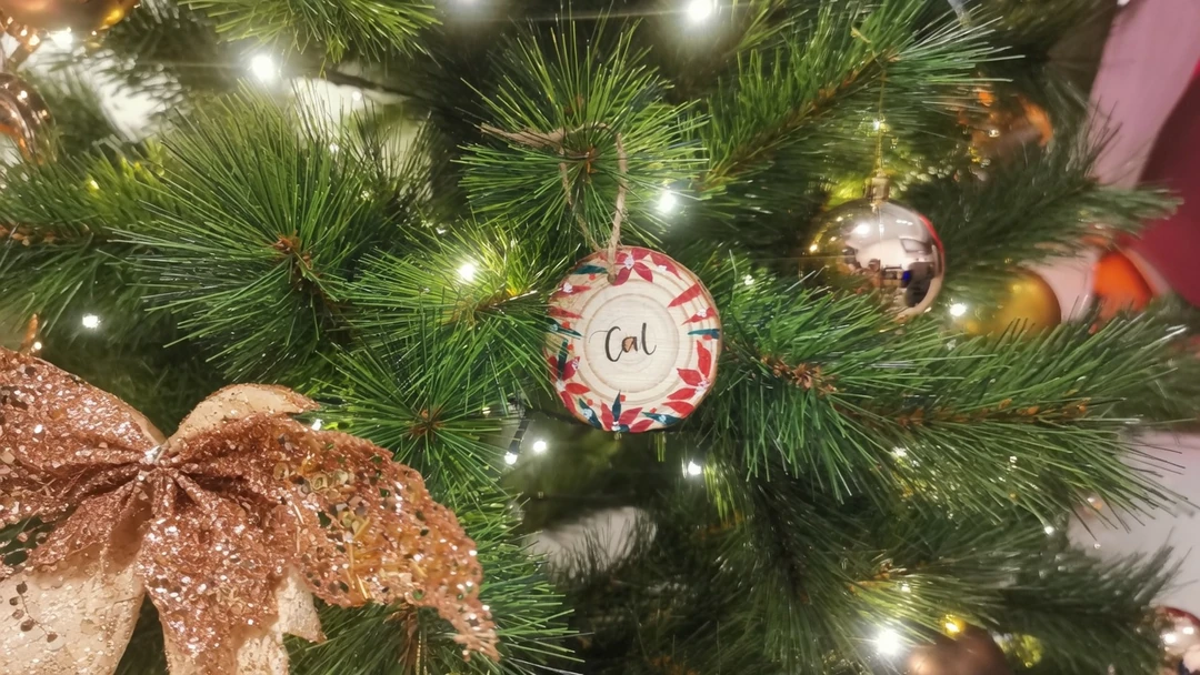 Handpainted christmas themed wood tags hanging on a christmas tree.jpg